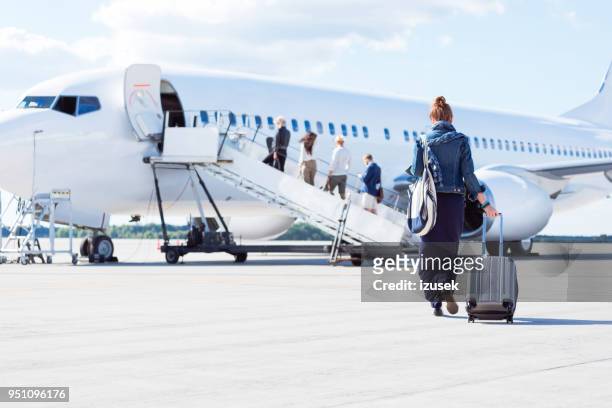 femme qui marche vers l’avion - embarquement photos et images de collection