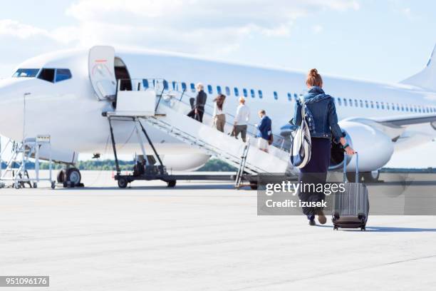 kvinna gående mot flygplan - airplane airport bildbanksfoton och bilder