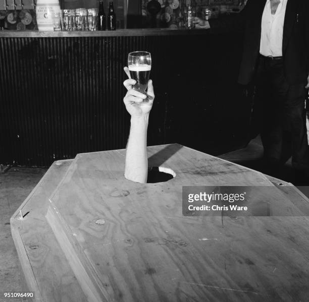 Year-old Irish builder, Mick Meaney holding up a glass of beer from inside his specially-made coffin, laid out upstairs at the Admiral Nelson pub in...