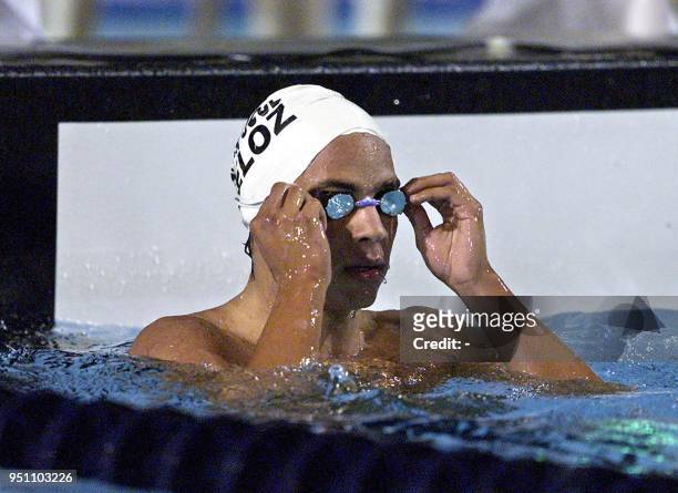 The Mexican swimmer Juan Jose Veloz Davila fixes his goggles, 25 November 2002 in San Salvador, after winning the 400 meter race of the XIX Central...