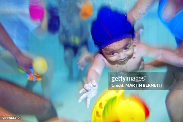 Carlos Medina, 5 months old, is seen swimming during a swimming class, in Quito, 21 March 2002. El nino Carlos Medina de 5 meses de edad busca un...