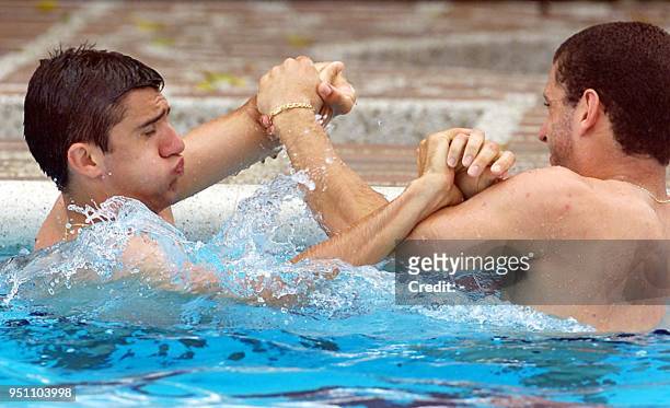 Fernando and Fabio Rochemback of the Brazilian soccer team wrestle in a pool, 20 July 2001, following a practice session at a country club in Cali,...