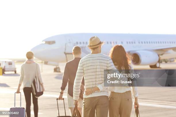 couple walking towards the airplane. - boarding plane stock pictures, royalty-free photos & images