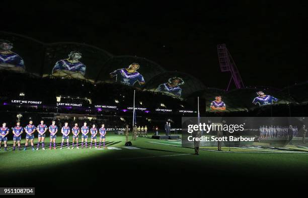 The Storm stand for a minutes silence during the round eight Anzac Day NRL match between the Melbourne Storm and New Zealand Warriors at AAMI Park on...