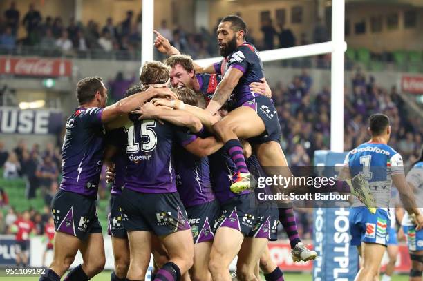 Christian Welch of the Melbourne Storm is congratulated by Josh Addo-Carr, Cameron Smith and his teammates after scoring a try as Peta Hiku of the...