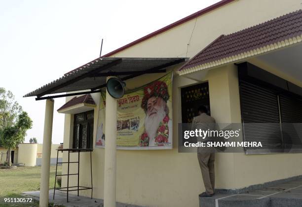 An Indian security personnel stands outside the ashram run by Asaram Bapu in Jalandhar on April 25, 2018. - An Indian guru with millions of followers...