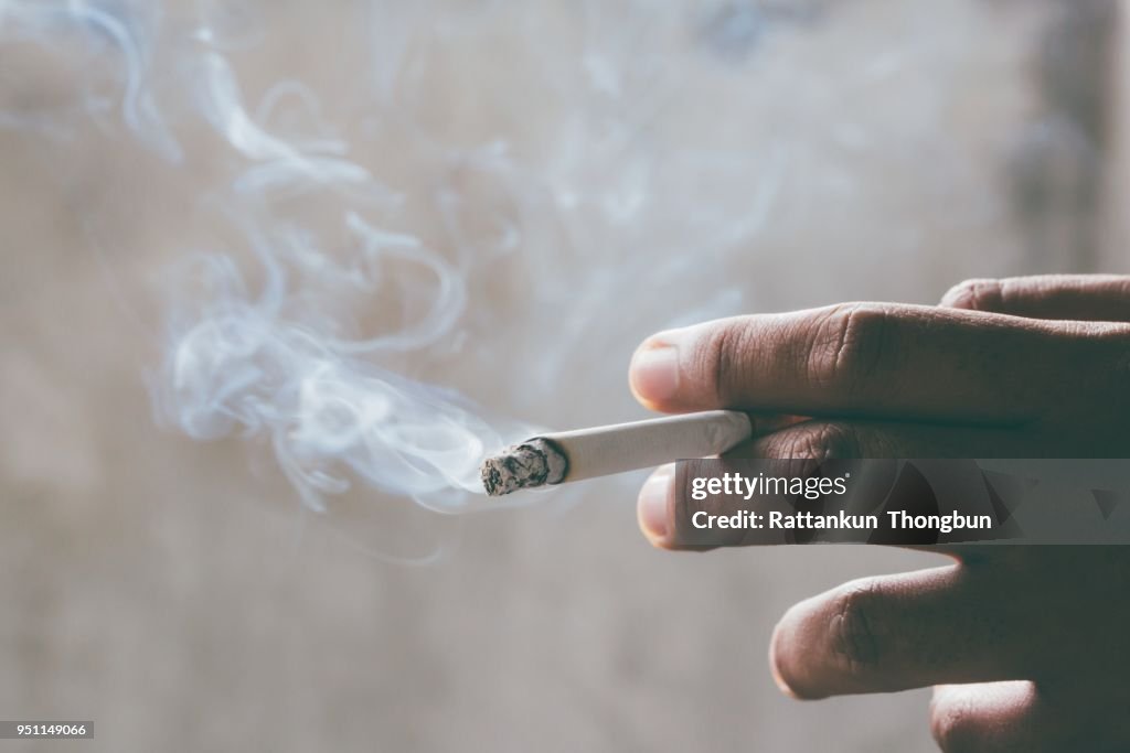 Fumer des Cigarettes au tabac dans la main avec un flou. concept de fumer des Cigarettes sont dangereuses pour la santé.