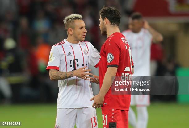 Rafinha of Muenchen speaks with Kevin Volland of Leverkusen during the DFB Cup semi final match between Bayer 04 Leverkusen and Bayern Munchen at...