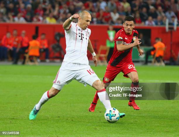 Arjen Robben of Muenchen and Charles Aranguiz of Leverkusen battle for the ball during the DFB Cup semi final match between Bayer 04 Leverkusen and...