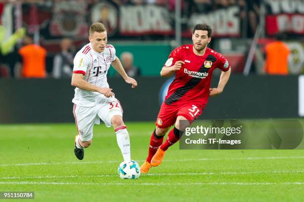 Joshua Kimmich of Bayern Muenchen and Kevin Volland of Leverkusen battle for the ball during the DFB Cup semi final match between Bayer 04 Leverkusen...