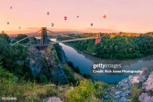 hot air balloons over clifton suspension bridge at sunrise - bristol fotografías e imágenes de stock