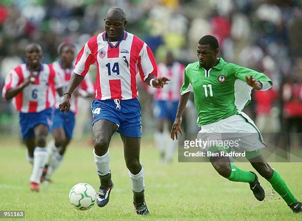 George Weah of Liberia takes the ball past Garba Lawal of Nigeria during the World Cup 2002 Group B Second Round Qualifying match played at Port...