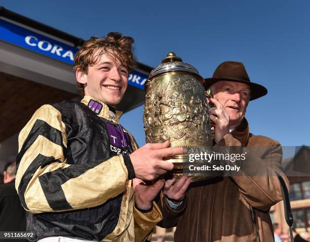 Naas , Ireland - 25 April 2018; Jockey David Mullins, left, and trainer Willie Mullins celebrate with the trophy after winning the Coral Punchestown...