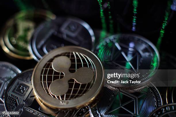 In this photo illustration of the litecoin, ripple and ethereum cryptocurrency 'altcoins' sit arranged for a photograph on April 25, 2018 in London,...