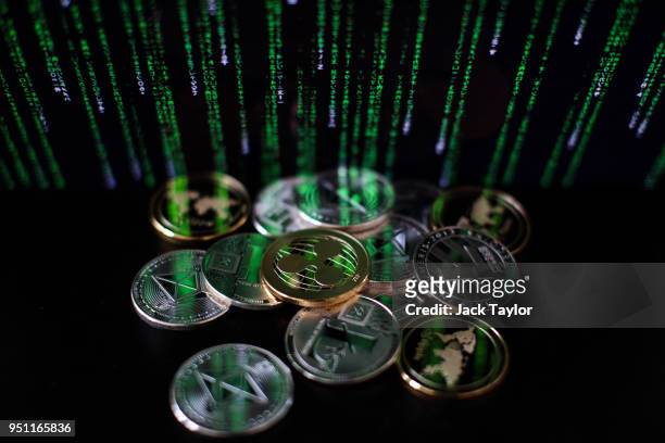 In this photo illustration of the litecoin, ripple and ethereum cryptocurrency 'altcoins' sit arranged for a photograph on April 25, 2018 in London,...