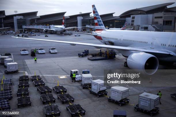 Cargo containers are transported to an American Airlines Group Inc. Plane at Los Angeles International Airport in Los Angeles, California, U.S., on...