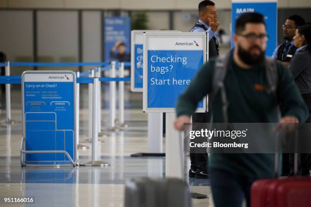 American Airlines Group Inc. Signage is displayed as travelers check in for flights at Dallas-Fort Worth International Airport in Grapevine, Texas,...