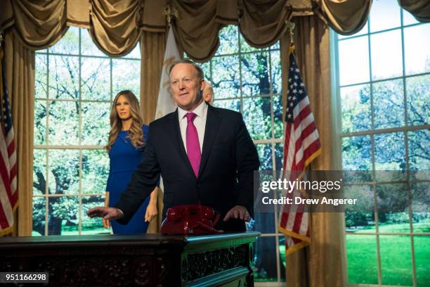 Former White House Press Secretary Sean Spicer stands with wax figures of first lady Melania Trump and President Donald Trump at Madame Tussauds wax...