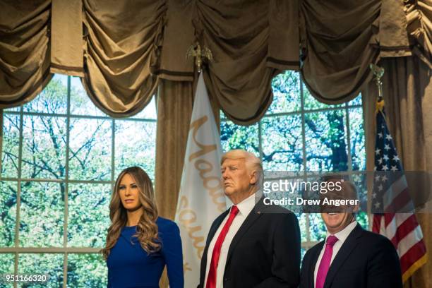 Former White House Press Secretary Sean Spicer stands with wax figures of first lady Melania Trump and President Donald Trump at Madame Tussauds wax...