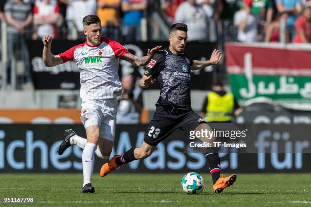 Jeffrey Gouweleeuw of Augsburg and Pablo de Blasis of Mainz battle for the ball during the Bundesliga match between FC Augsburg and 1. FSV Mainz 05...