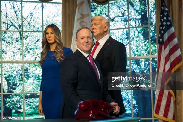 Former White House Press Secretary Sean Spicer stands with wax figures of first lady Melania Trump and President Donald Trump at Madame Tussauds wax...