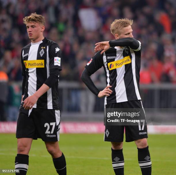 Michael Cuisance of Moenchengladbach and Oscar Wendt of Moenchengladbach look dejected after the Bundesliga match between FC Bayern Muenchen and...