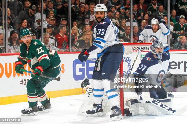 Connor Hellebuyck and Dustin Byfuglien of the Winnipeg Jets defend against Nino Niederreiter of the Minnesota Wild in Game Four of the Western...