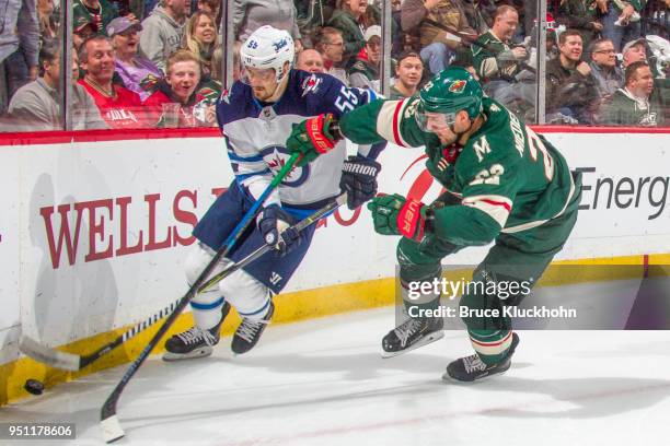 Mark Scheifele of the Winnipeg Jets and Nino Niederreiter of the Minnesota Wild battle for the puck along the boards in Game Four of the Western...