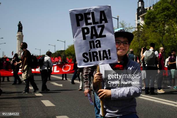 Young child holds a placard reading 'for the peace in Siria!' in central Lisbon on April 25, 2018 during a rally to celebrate the 44th anniversary of...