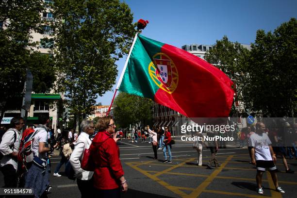 Man holds a Portuguese flag in central Lisbon on April 25, 2018 during a rally to celebrate the 44th anniversary of the Portuguese revolution.