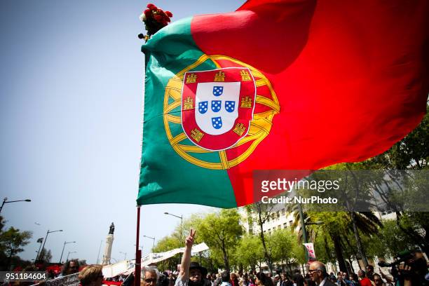 Man holds a Portuguese flag in central Lisbon on April 25, 2018 during a rally to celebrate the 44th anniversary of the Portuguese revolution.