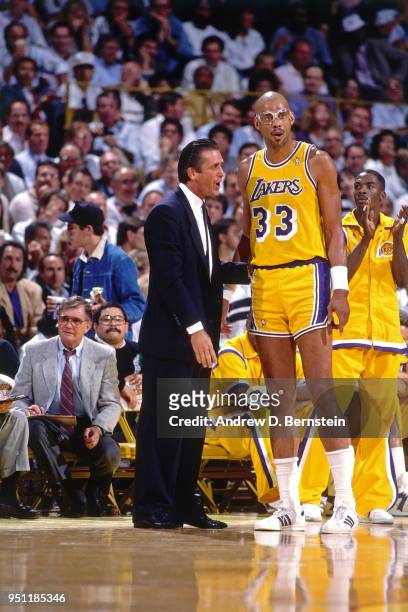 Head Coach Pat Riley speaks to Kareem Abdul-Jabbar of the Los Angeles Lakers during a game circa 1988 at The Forum in Inglewood, California. NOTE TO...
