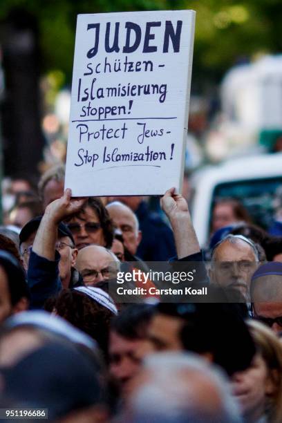 Participant shows a banner during a "wear a kippah" gathering to protest against anti-Semitism in front of the Jewish Community House on April 25,...
