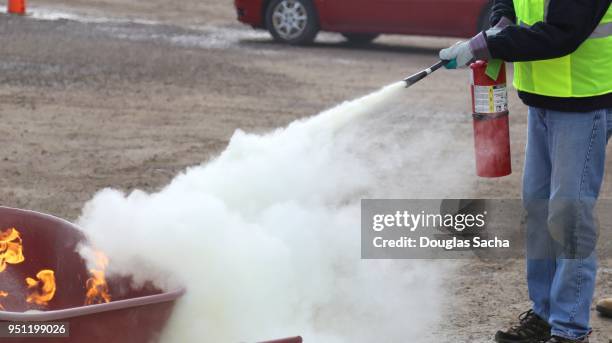rescue worker in training practices with a fire extinguisher - fire extinguisher stock pictures, royalty-free photos & images