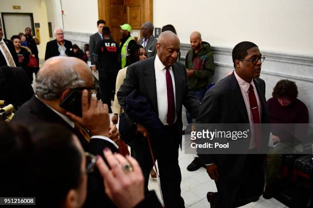 Bill Cosby, center, is lead by spokesperson Andrew Wyatt to a private room during a break in Cosby's sexual assault trial at the Montgomery County...