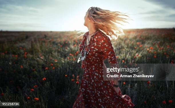 dancing woman in poppy field - hippie stockfoto's en -beelden