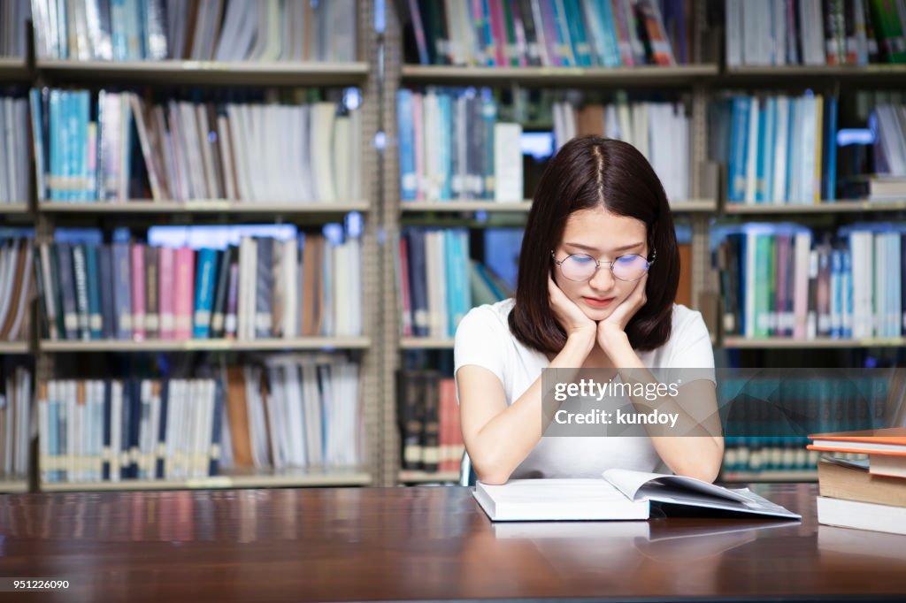 Student reading a book in library.