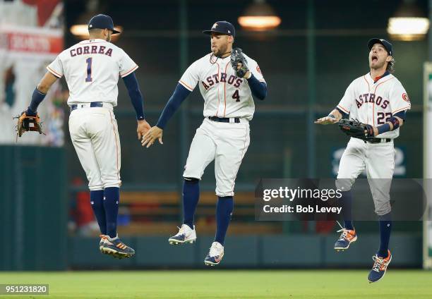 Carlos Correa of the Houston Astros celebrates with George Springer as Josh Reddick looks on after the final out against the Los Angeles Angels of...