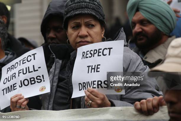 Woman holds a paper reading "Respect the Drivers" during a rally in New York City after New York Taxi Workers Alliance group claimed that four...