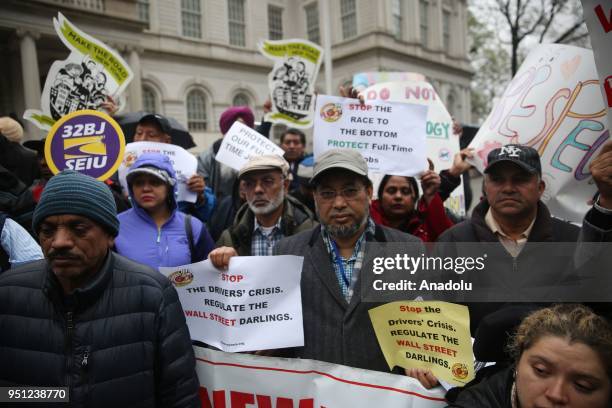 Families of yellow cab drivers hold banners demanding protection of full-time jobs during a rally in New York City after New York Taxi Workers...