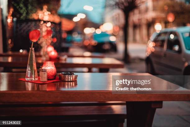 restaurant table with tulip, candle and ashtray with blurried street lights - restaurant night ストックフォトと画像