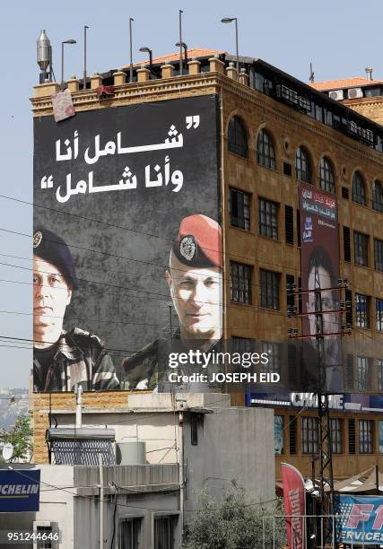 Picture taken on April 17, 2018 shows a poster of Lebanese candidate for the upcoming parliamentary elections Chamel Roukoz and his stepfather...