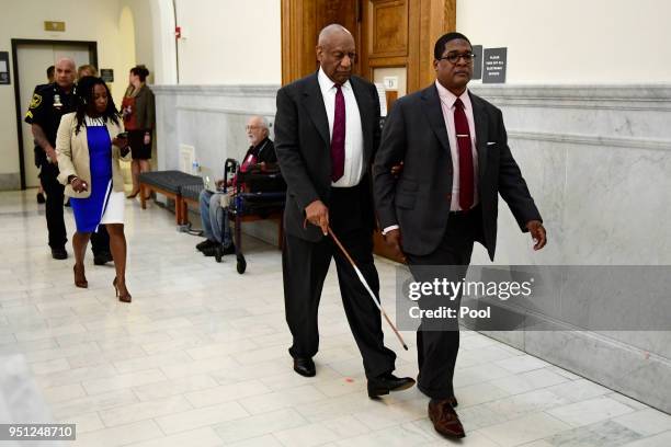 Bill Cosby, center, is led by spokesperson Andrew Wyatt as publicist Ebonee Benson follows during a break in his sexual assault trial at the...