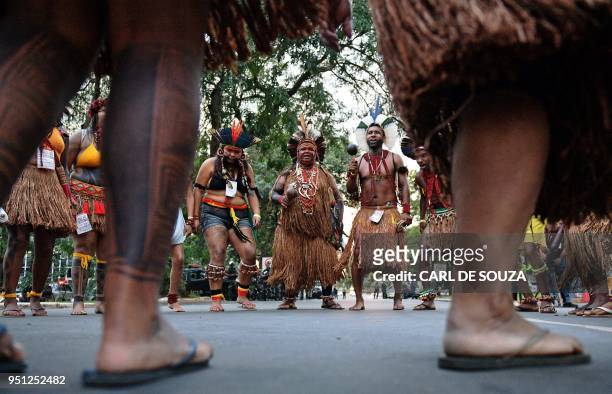 Brazilian indigenous men perform a ritual dance during a protest against the government's decision not to recognize the land demarcation of...