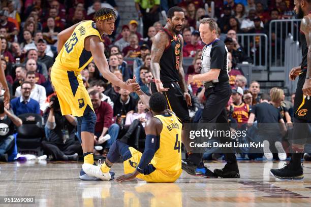 Myles Turner of the Indiana Pacers helps Victor Oladipo of the Indiana Pacers off of the flor during the game against the Cleveland Cavaliers in Game...