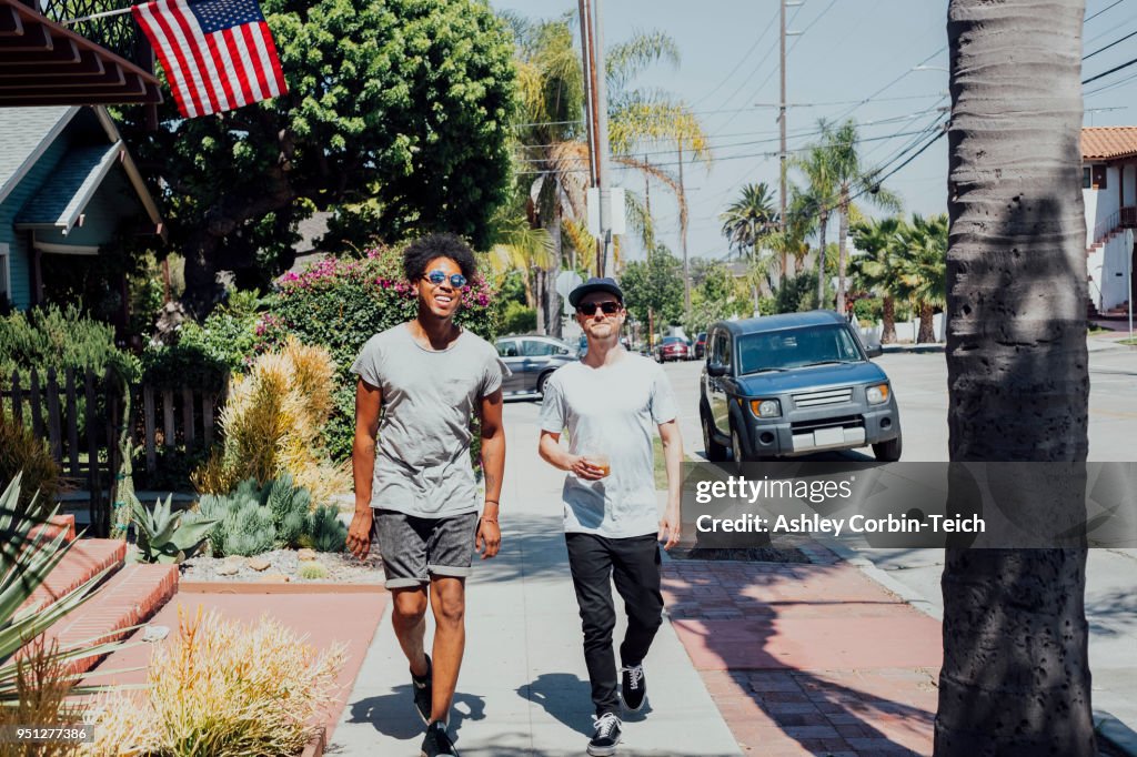 Friends walking down sunny street, Long Beach, California, US