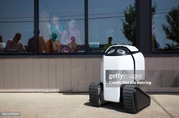 Children and others gather to look at delivery robot 'DAX' en route to deliver burritos on April 25, 2018 in Philomath, Oregon. Joseph Sullivan, the...