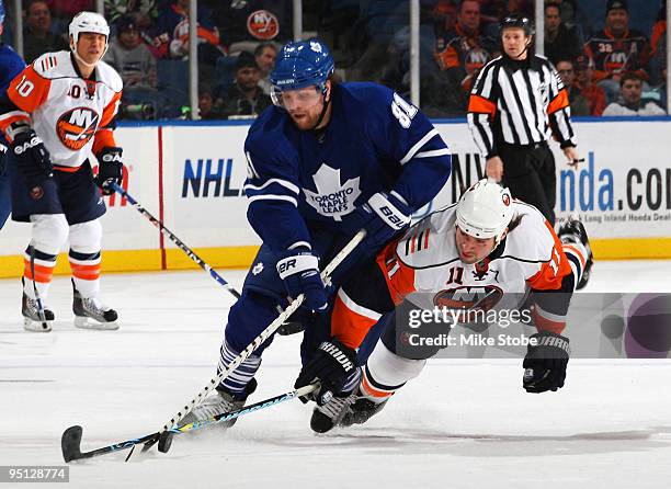 Phil Kessel of the Toronto Maple Leafs tries to get past a diving Nate Thompson of the New York Islanders on December 23, 2009 at Nassau Coliseum in...