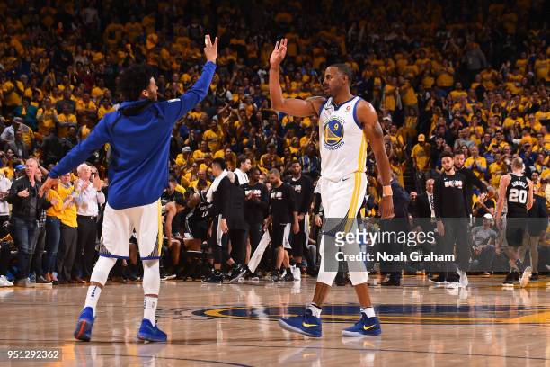 Quinn Cook and Andre Iguodala of the Golden State Warriors exchange a high five against the San Antonio Spurs Game Five of Round One of the 2018 NBA...