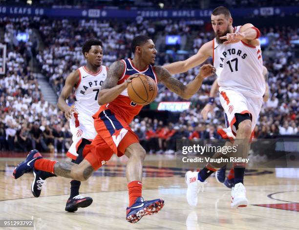 Bradley Beal of the Washington Wizards drives to the basket as Jonas Valanciunas of the Toronto Raptors defends during the first half of Game Five in...